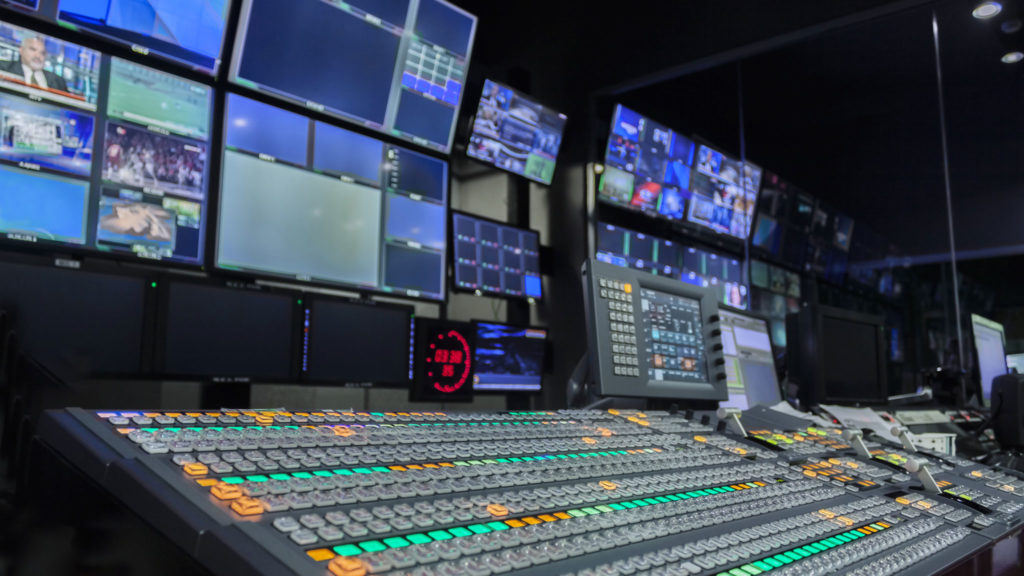 Broadcast media production room with switching boards and audio controls